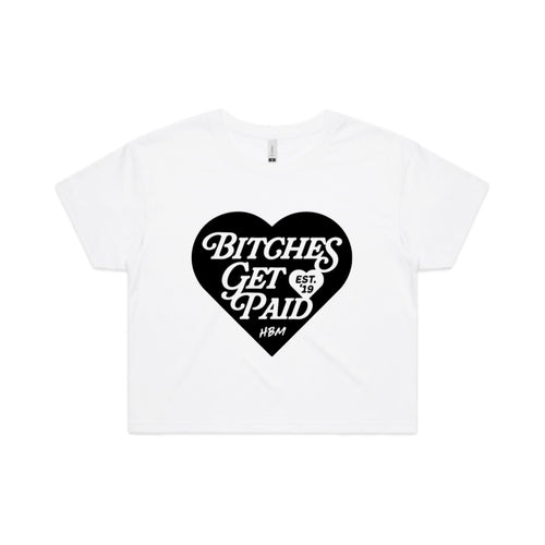 A white crop top shirt with a black heart logo containing text that reads 'BITCHES GET PAID' on a white background